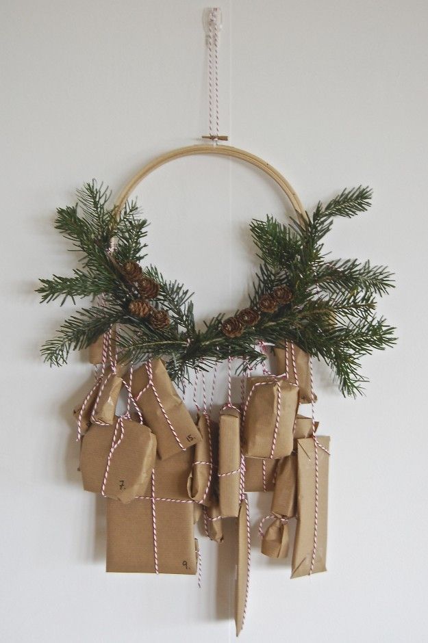 An embroidery hoop holds the greenery and the advent gifts tied on with red and white baker's twine.